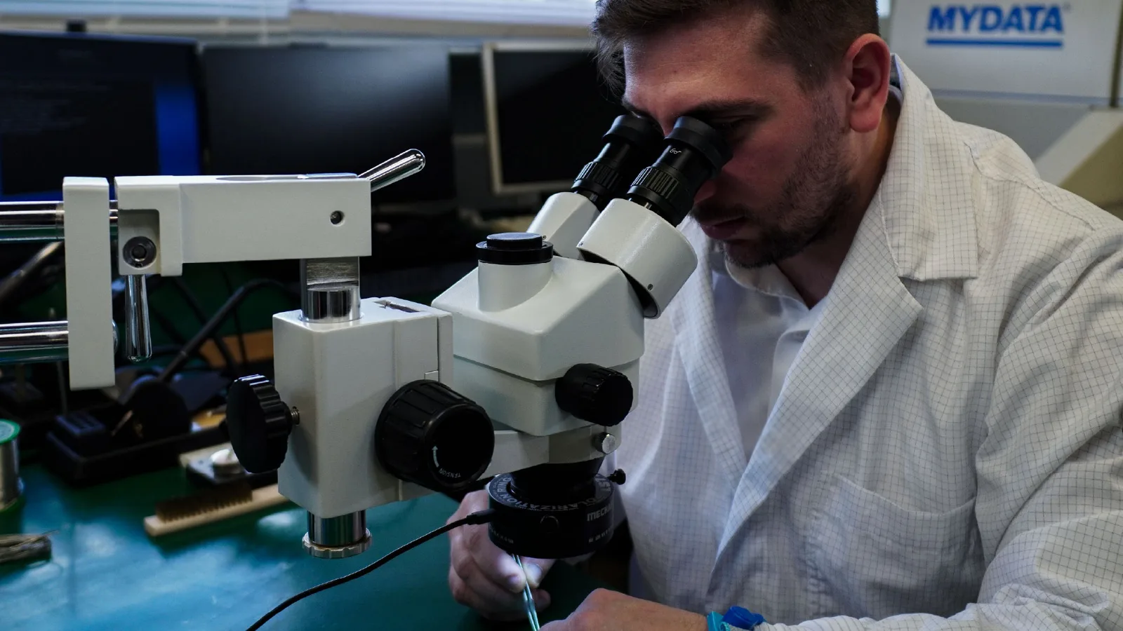 Technicien EVIACORE examinant une carte électronique au microscope